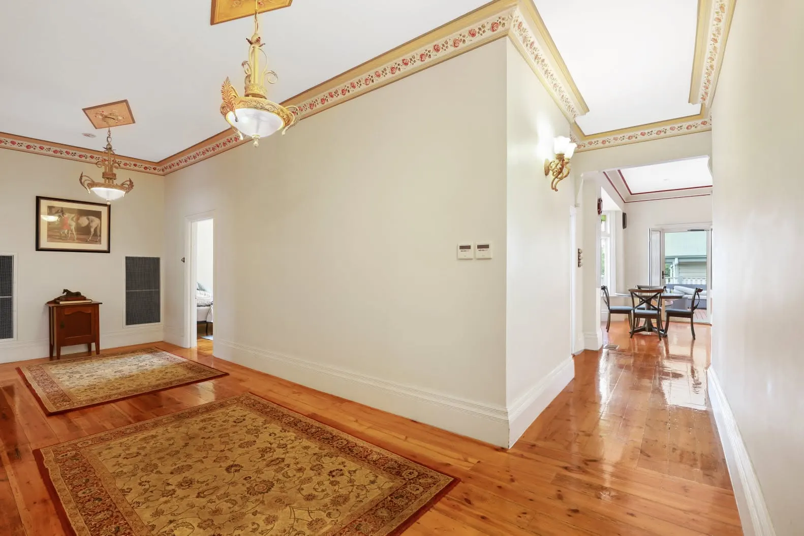 Period hallway with ornate cornices and Persian rugs